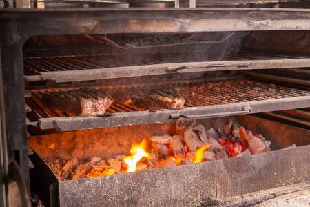 food, craft and delicious concept - cooking steak on a grillの写真素材