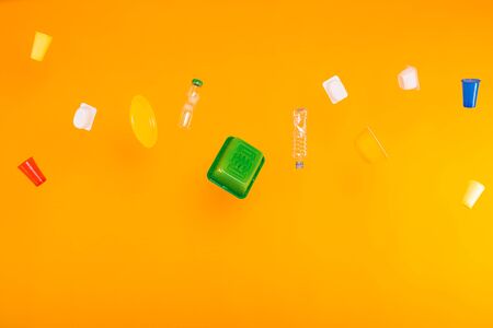 Problem of trash, plastic recycling, pollution and environmental concept - plastic garbage on yellow...