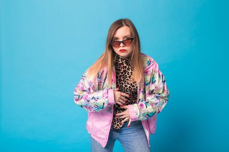 Vintage fashion look concept - pretty young woman wearing a retro pink jacket and leopard body on...