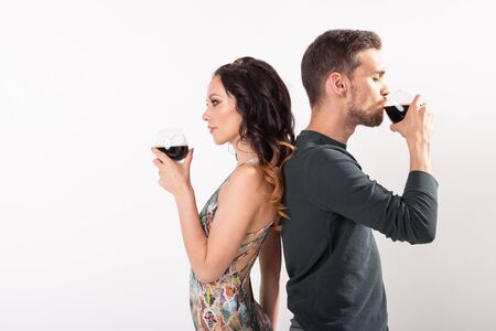 Man and woman are holding glasses of dark beer on white background with copy space. Oktoberfest...