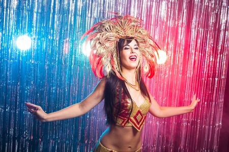 Carnival, dancer and holiday concept - Beauty brunette woman in cabaret suit and headdress with natural feathers and rhinestones.の写真素材
