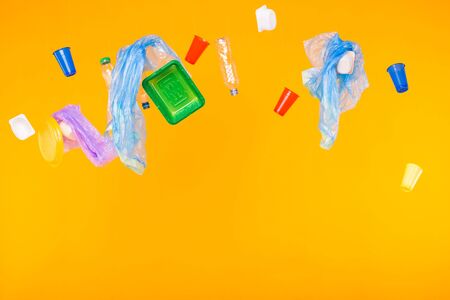 Problem of trash, plastic recycling, pollution and environmental concept - plastic garbage on yellow...