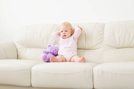 Child, childhood and kids concept - Portrait of charming baby girl on the couch
