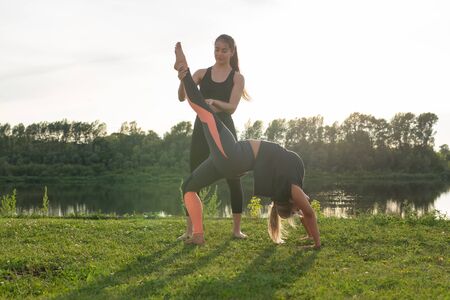 Healthy lifestyle and harmony concept - Young girls doing yoga outdoor