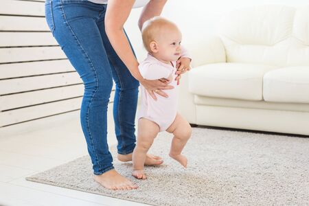 little baby girl first steps with the help of momの写真素材