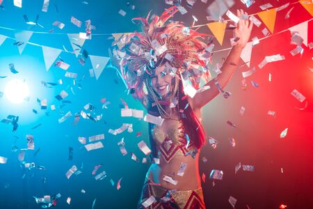 Carnival, dancer and holiday concept - Portrait of a sexy female in a colorful sumptuous carnival feather suit. Nightlife of female dancerの写真素材