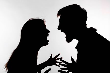 Aggression and abuse concept - man and woman expressing domestic violence in studio silhouette isolated on white background.の写真素材