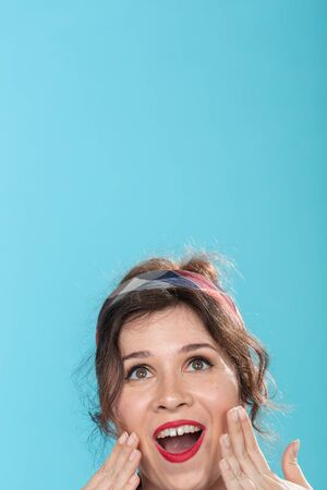 fashion and people concept - pin-up woman looking up on blue background with copy space