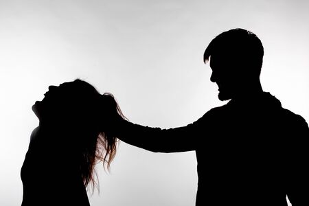 Aggression and abuse concept - man and woman expressing domestic violence in studio silhouette isolated on white backgroundの写真素材