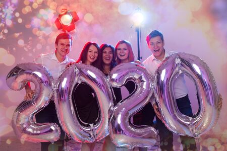 Party, people and new year holidays concept - women and men celebrating new years eve 2020の写真素材