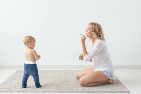 Cute single mother and kid girl playing together indoor at homeの写真素材