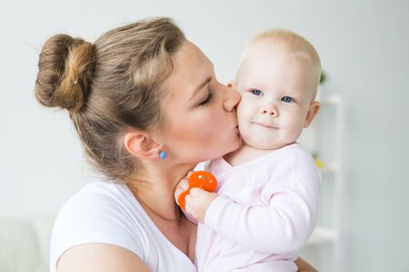 Mother hugs little baby. Happy woman with her daughter close-upの写真素材