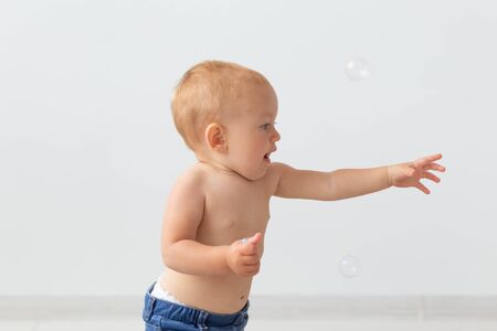 childhood, babyhood, emotions and people concept - close up of happy little baby boy or girl at homeの写真素材