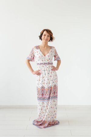 people, fashion and style concept - young woman posing in clothes in studio on white backgroundの写真素材