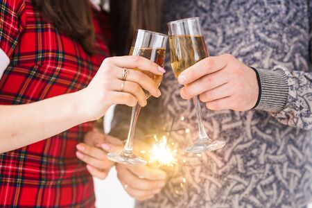 Close up of hands holding sparklers and champagne glasses. Firework celebrate at night happy new yearの写真素材