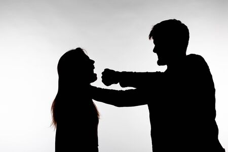 Aggression and abuse concept - man and woman expressing domestic violence in studio silhouette...