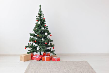 Holidays, celebration and gifts concept - Christmas tree and many present boxes on white indoors with copy space.の写真素材