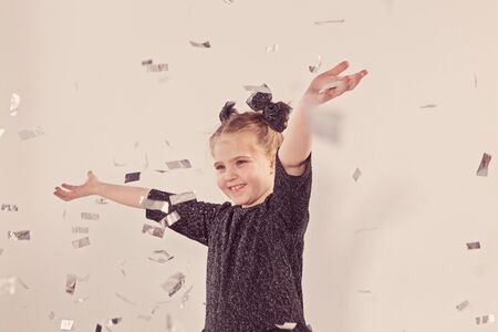 Party, holidays, new year and celebration concept - Female child throwing confetti.の写真素材