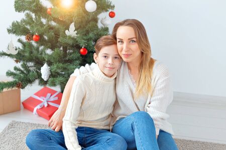 Single parent and holidays concept - Portrait of mother celebrating christmas at home on christmas eveの写真素材
