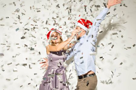 New year, christmas and party concept - Cheerful young people showered with confetti on a white background.の写真素材