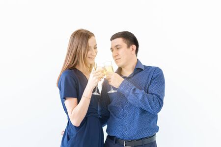 Man and woman celebrating Christmas or New Year eve party with glasses of champagne on white...