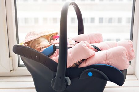 Childhood and safety concept - Infant baby girl sleeping in child car seat