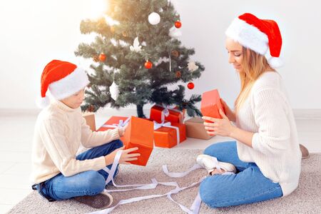 Single parent and holidays concept - Portrait of mother and son celebrating christmas at home on christmas eveの写真素材
