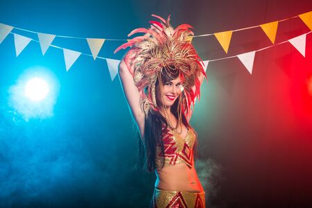 Carnival, dancer and holiday concept - Beauty brunette woman in cabaret suit and headdress with...