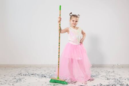 Pretty female child cleaning apartment after christmas partyの写真素材
