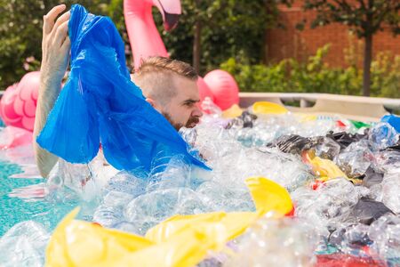Ecology, plastic trash, environmental emergency and water pollution - shocked man swim in a dirty...