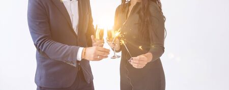Valentines day and date concept - Couple with champagne glasses and sparklers on white background.の写真素材