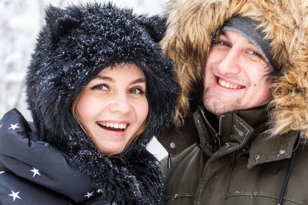 Young couple in love have fun in the snowy forest. Active winter holidays.の写真素材