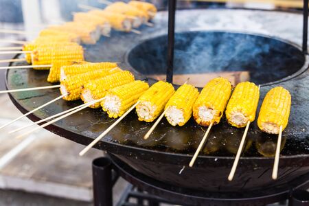 Preparing hot grilled corn outdoors at summer. Asian street foodの写真素材