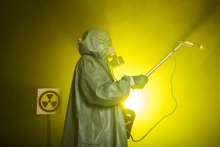 Man in the gas mask and chemical suit. The worker doing measure radioactivityの写真素材