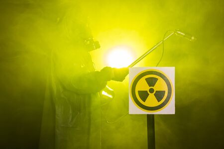 Man in the gas mask and chemical suit. The worker doing measure radioactivity