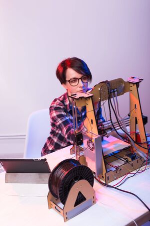 Female architect using 3D printer in office