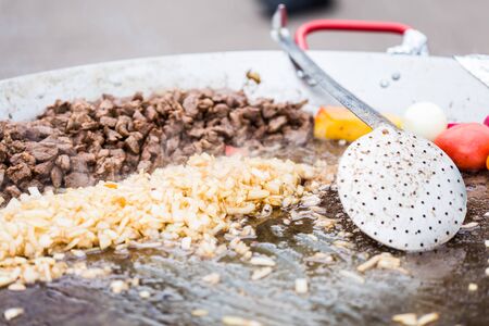 Delicious slices meat on open grill, outdoor kitchen. Food festival in city. Tasty food roasting, food-court. Summer picnicの写真素材