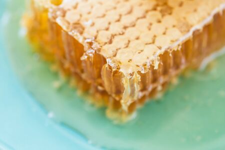 Honey with honeycombs on a plate, close-up.の写真素材