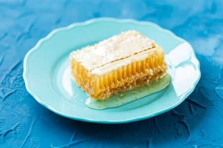 Honey with honeycombs on a plate, close-upの写真素材