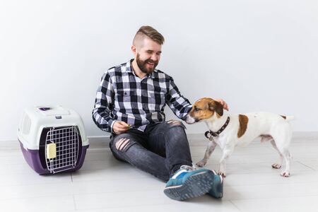 Dog carrying bags and pets owner concept - Attractive cheerful male in plaid shirt holds favourite...