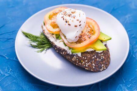 Sandwich with smoked salmon, egg and avocado on blue background, top view.の写真素材