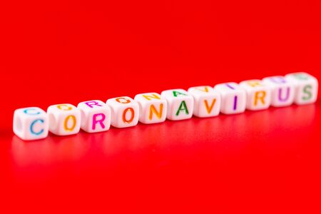 Pandemic and virus concept - Coronavirus word made of colourful blocks. Coronavirus text on red background. Coronavirus concept top view.の写真素材
