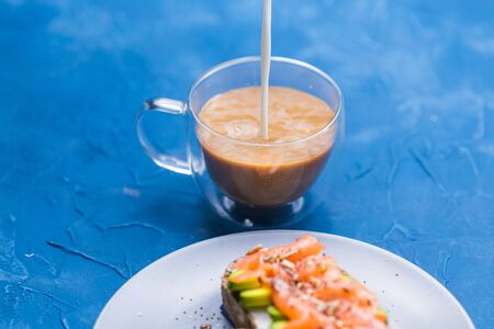 Morning and breakfast concept - Pouring cream into a cup of coffee