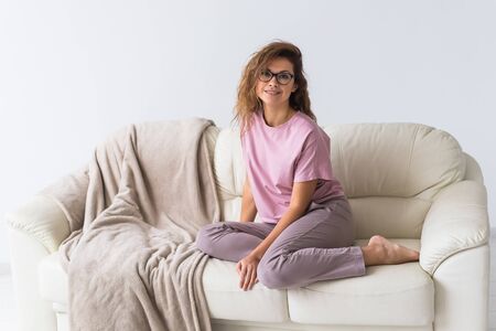 Young attractive woman dressed in beautiful colorful pajama posing as a model in her living room. Comfortable sleepwear, home relaxation and female fashion concept.の写真素材