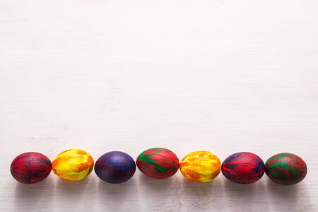 Holidays, traditions and Easter concept - Multi-colored decorative colourful eggs on white background with copy space. Top view.の写真素材