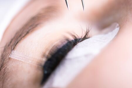 Eyelash Extension Procedure. Woman Eye with Long Eyelashes. Lashes, close up, selective focus.