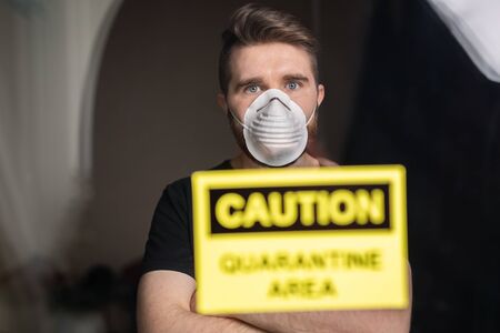 Coronavirus, quarantine and pandemic concept. Sad and sick man of corona virus looking through the...