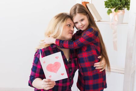 Mothers Day and family holidays - Mother reading greeting card from her daughter.の写真素材