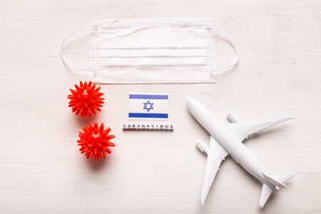 Plane model and face mask and flag Israel. Coronavirus pandemic. Flight ban and closed borders for tourists and travelers with coronavirus covid-19 from Europe and Asia.の写真素材