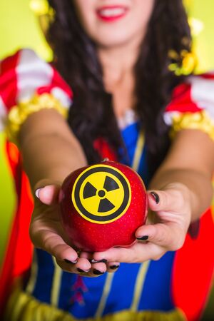 Woman dressed as fairytale character holds Radioactive atomic nuclear ionizing radiation danger...